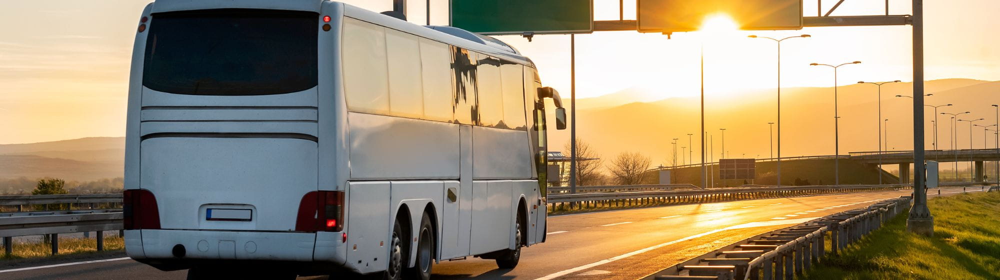 Bus qui est sur l’autoroute devant un coucher de soleil